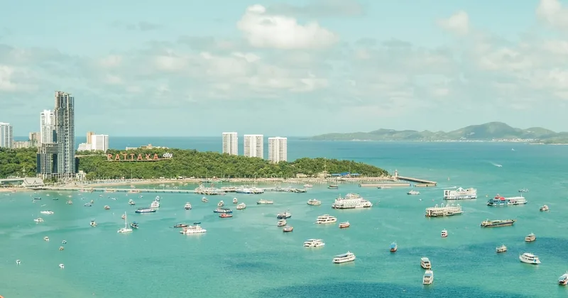 Bateaux dans la baie de Pattaya sous les lettres de la colline de Pattaya City.